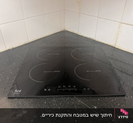 כיריים על משטח שיש כהה במטבח